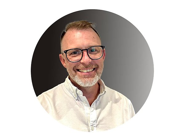 man med glasögon och vit skjorta